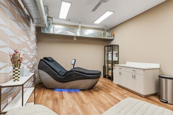 A modern room with a bean bag chair and a small table with a vase of flowers on it.